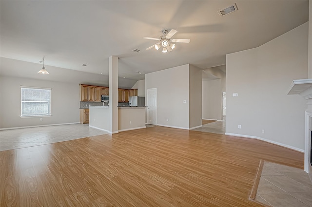 unfurnished living room with ceiling fan and light hardwood / wood-style floors