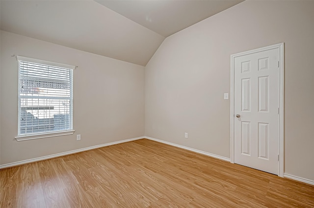 empty room with lofted ceiling and light wood-type flooring