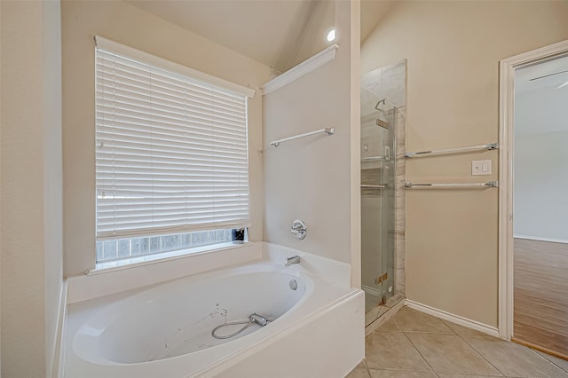 bathroom with tile patterned flooring, separate shower and tub, and vaulted ceiling