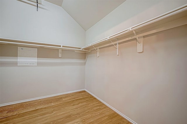 walk in closet with hardwood / wood-style floors and lofted ceiling