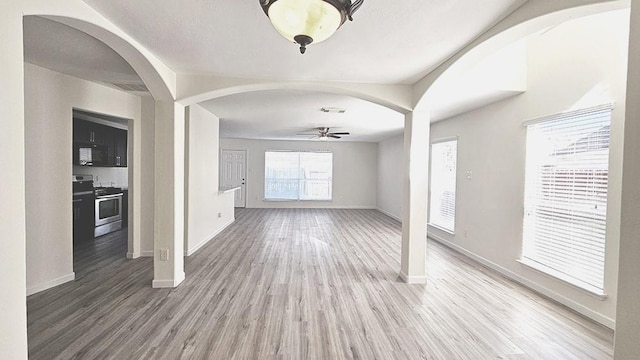 unfurnished living room featuring ceiling fan and hardwood / wood-style flooring