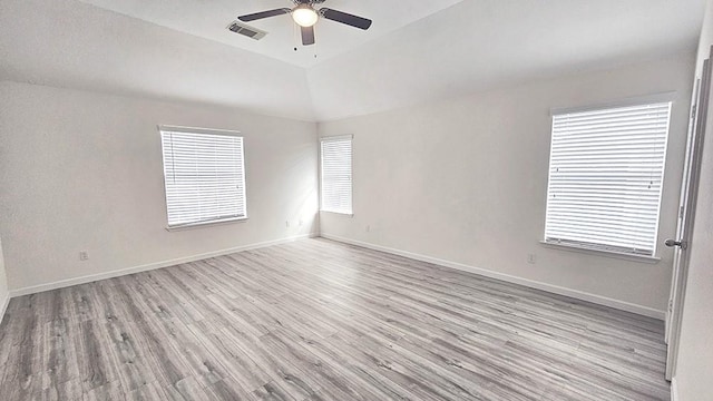 empty room featuring ceiling fan, lofted ceiling, and light hardwood / wood-style flooring