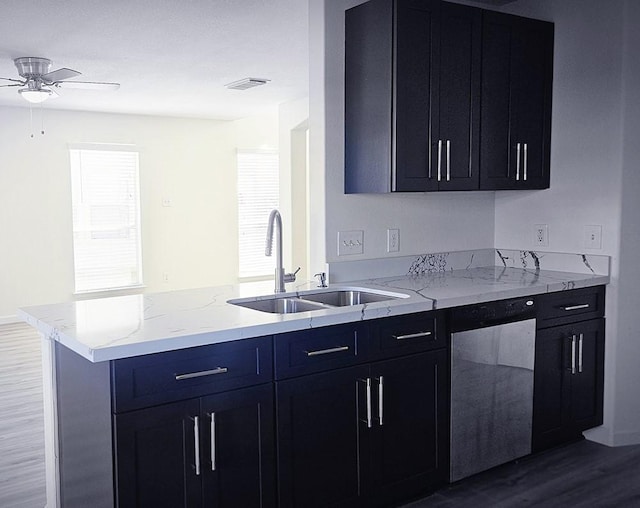 kitchen featuring stainless steel dishwasher, a healthy amount of sunlight, sink, and hardwood / wood-style floors