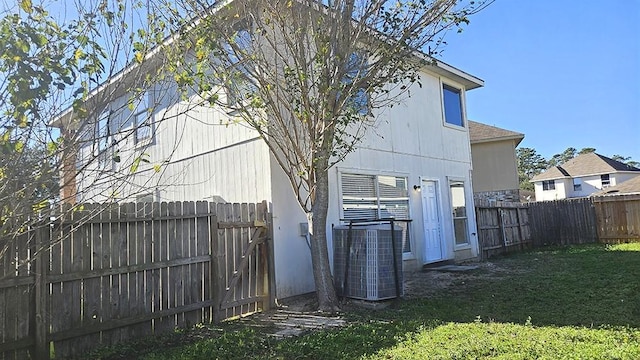 rear view of house with a yard and central air condition unit