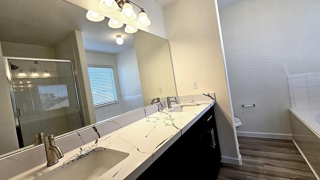 full bathroom featuring toilet, vanity, wood-type flooring, and shower with separate bathtub