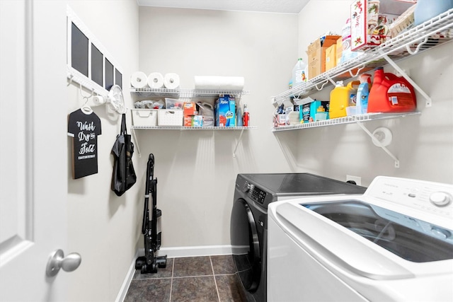 laundry room with washer and dryer and dark tile patterned flooring