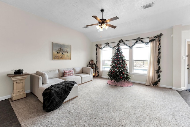 living room featuring lofted ceiling, ceiling fan, and a textured ceiling