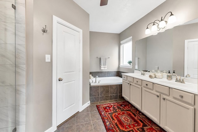 bathroom with tiled bath, ceiling fan, tile patterned floors, and vanity