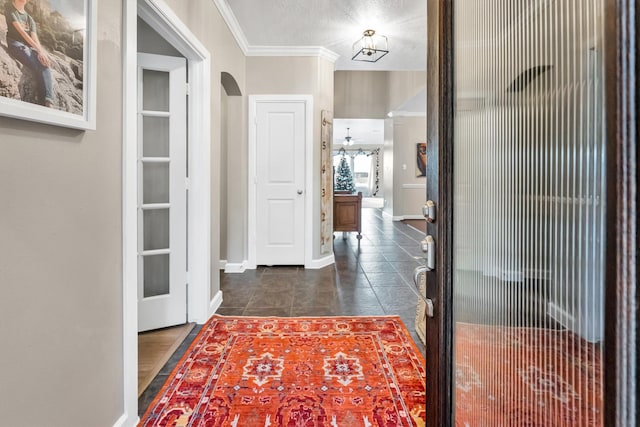 hallway featuring a textured ceiling and ornamental molding