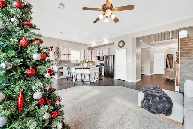 living room featuring ceiling fan, sink, and dark tile patterned floors