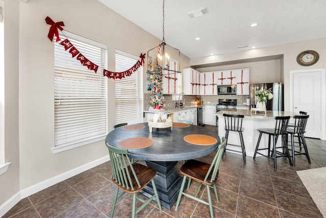 dining space with sink and a chandelier