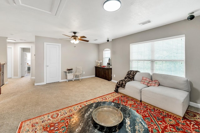 carpeted living room with ceiling fan