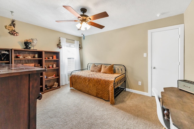 bedroom with ceiling fan, light colored carpet, and a textured ceiling