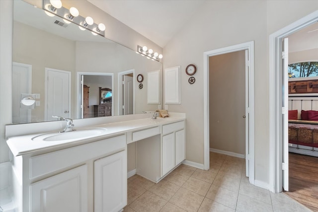 bathroom featuring tile patterned flooring, vanity, and vaulted ceiling