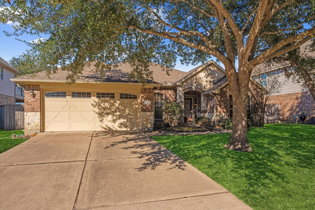 ranch-style house featuring a garage and a front lawn