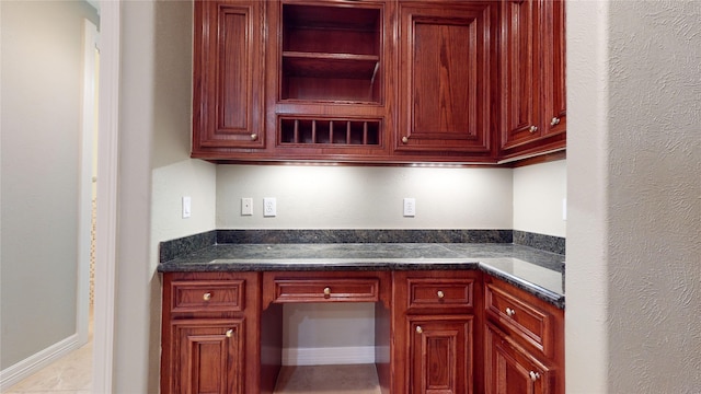 kitchen with light tile patterned flooring and dark stone countertops