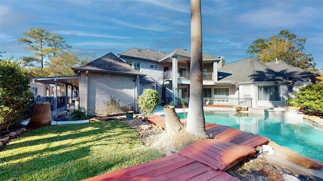 rear view of property featuring a yard and a balcony