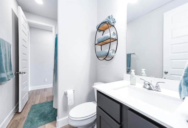 bathroom with hardwood / wood-style floors, vanity, and toilet