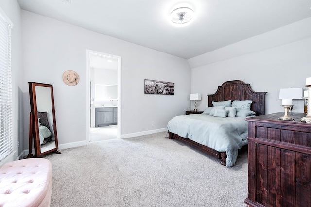 carpeted bedroom featuring ensuite bathroom and vaulted ceiling