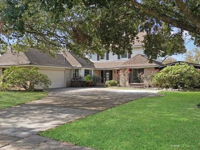 traditional home with a front lawn, an attached garage, concrete driveway, and roof with shingles