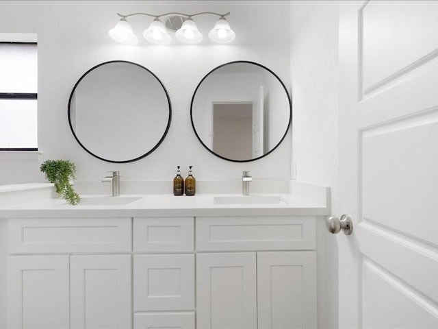 full bathroom with double vanity and a sink