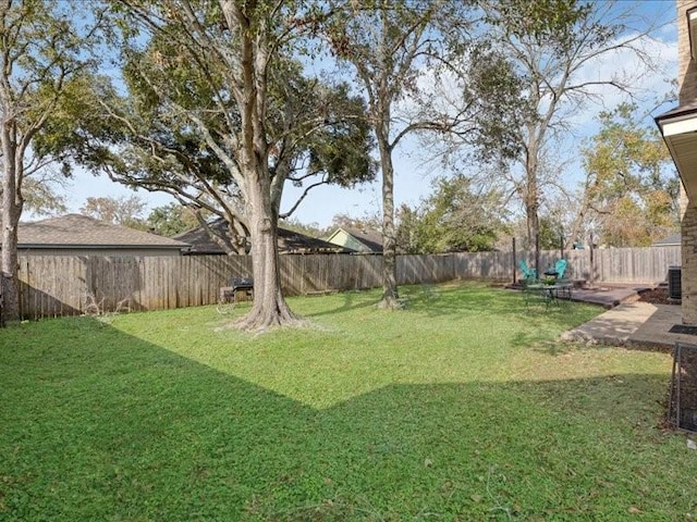 view of yard with central AC and a fenced backyard