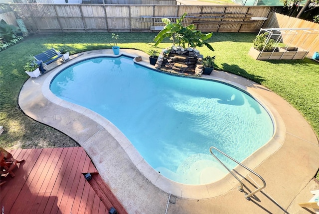 view of swimming pool with a lawn and a deck