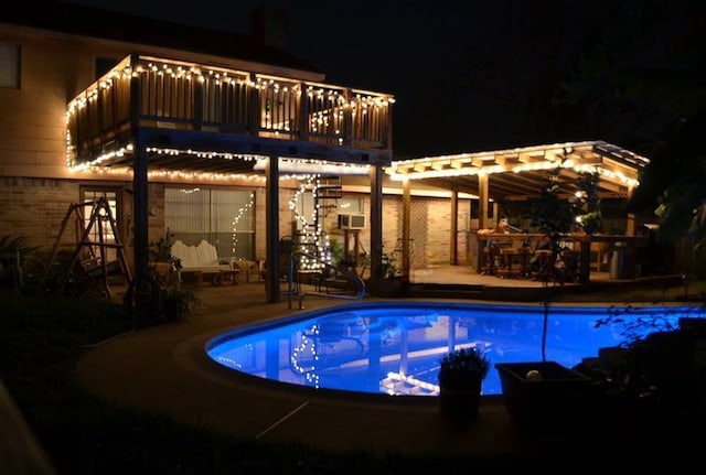 pool at twilight featuring a patio