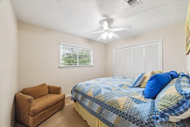 bedroom featuring ceiling fan, a closet, carpet floors, and a textured ceiling