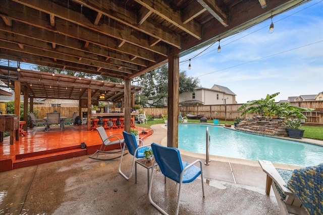 view of pool with an outdoor bar and a wooden deck