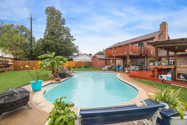 view of pool featuring a fire pit, a yard, and a wooden deck