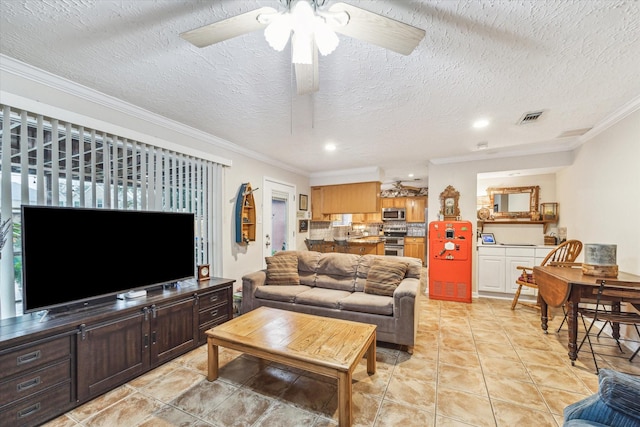 living room with a textured ceiling, ceiling fan, ornamental molding, and light tile patterned flooring