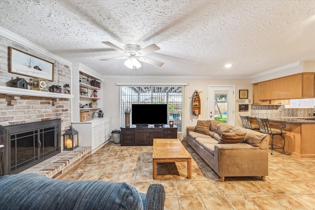 living room with ceiling fan, a fireplace, a textured ceiling, and ornamental molding