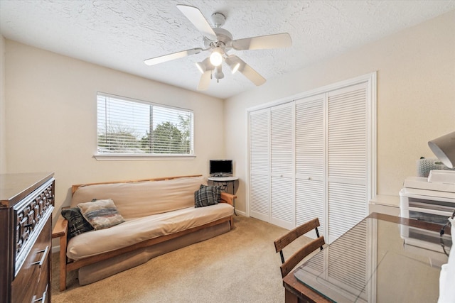 office area featuring carpet flooring, ceiling fan, and a textured ceiling