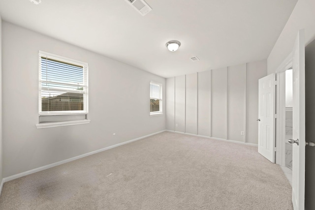 carpeted spare room featuring a healthy amount of sunlight