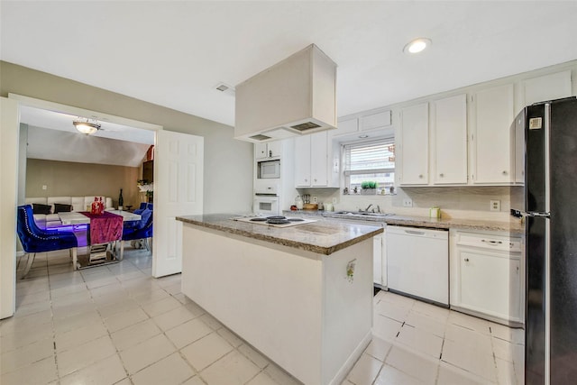 kitchen with white cabinetry, a kitchen island, white appliances, and light tile patterned floors