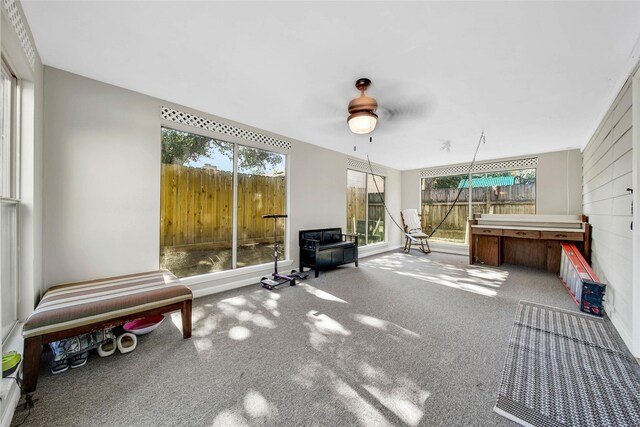 unfurnished sunroom featuring ceiling fan