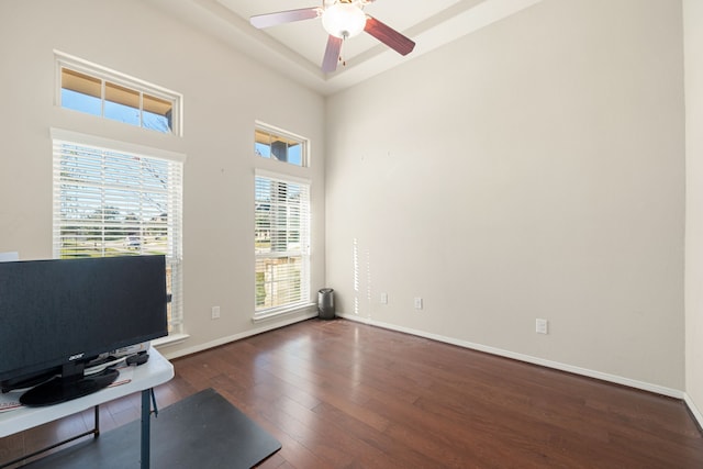 office area with a high ceiling, ceiling fan, and dark wood-type flooring