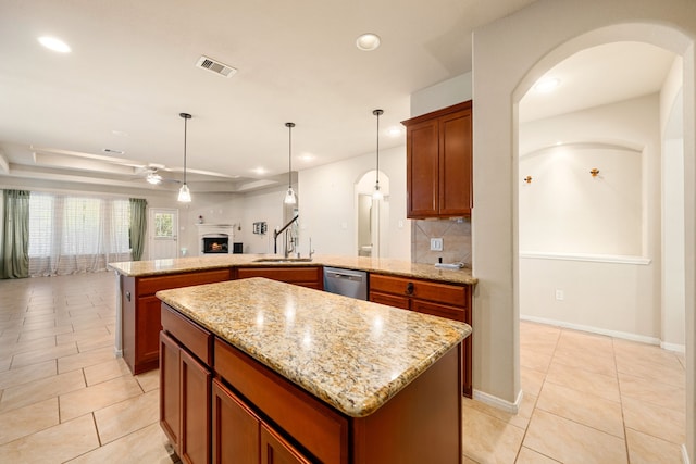 kitchen featuring a center island, sink, stainless steel dishwasher, decorative light fixtures, and light tile patterned flooring