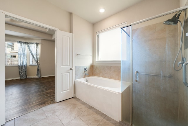 bathroom featuring tile patterned flooring, plus walk in shower, and a healthy amount of sunlight