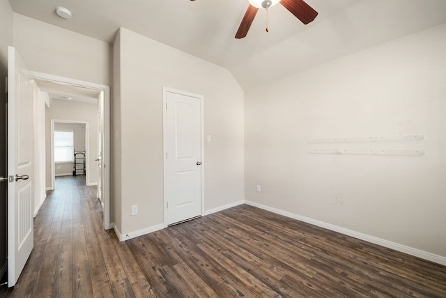 empty room featuring ceiling fan, dark wood-type flooring, and vaulted ceiling