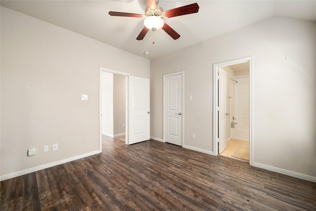 unfurnished bedroom featuring dark hardwood / wood-style flooring, connected bathroom, vaulted ceiling, and ceiling fan