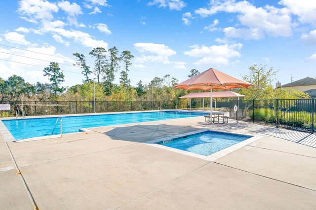 view of pool with a patio and a hot tub