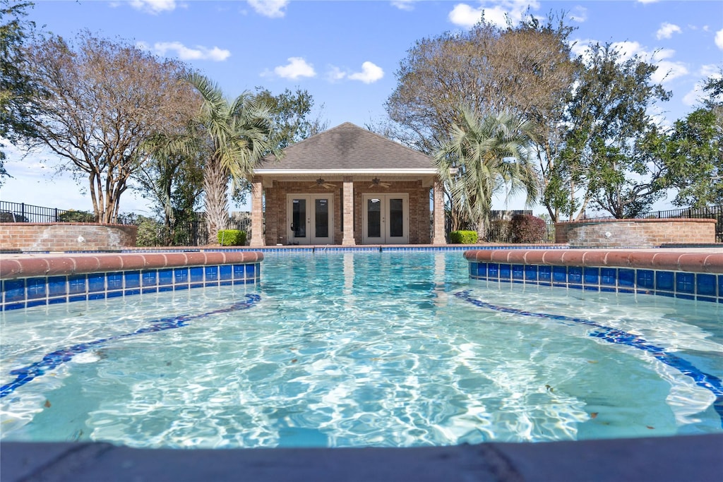 view of pool with ceiling fan and french doors