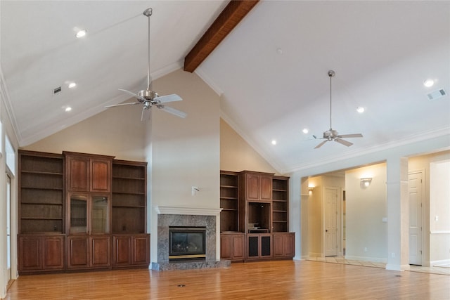 unfurnished living room with light hardwood / wood-style flooring, high vaulted ceiling, beamed ceiling, crown molding, and a fireplace