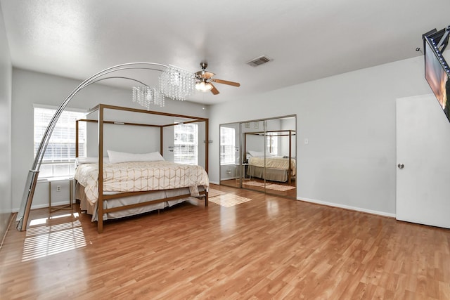 bedroom featuring multiple windows, hardwood / wood-style floors, and ceiling fan