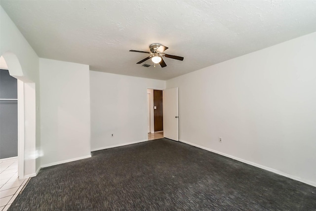 carpeted spare room featuring ceiling fan and a textured ceiling