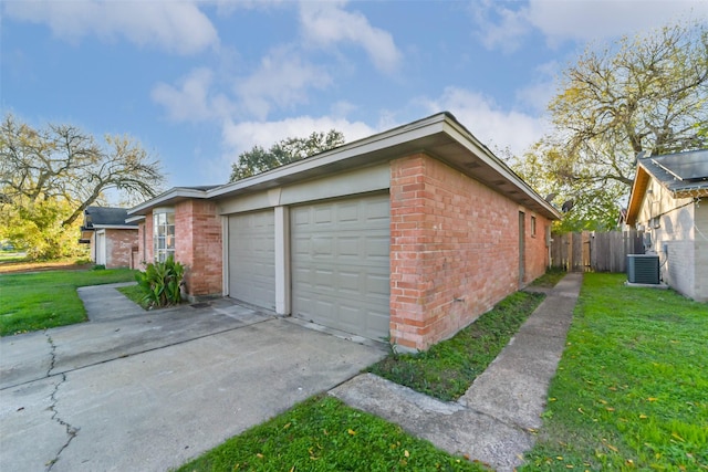 exterior space featuring a garage, a yard, and central AC