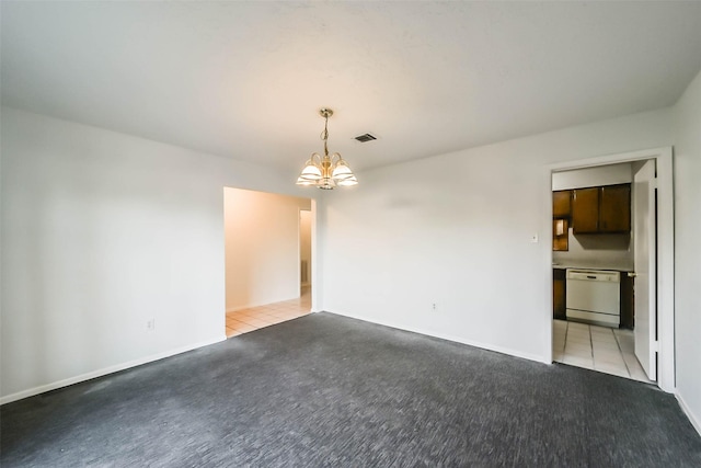 carpeted spare room with a notable chandelier