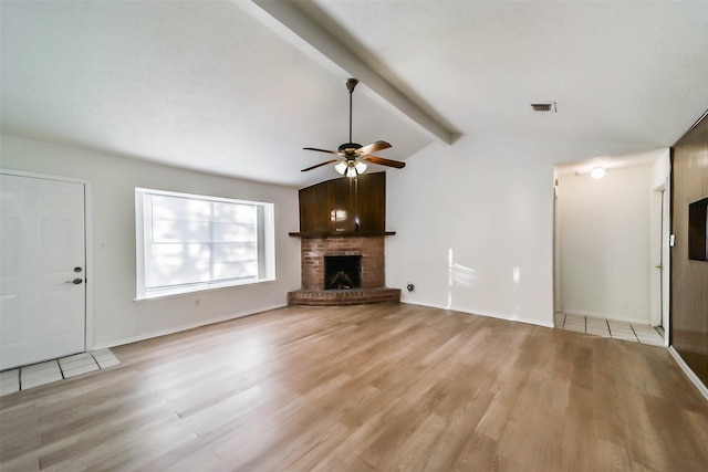 unfurnished living room featuring vaulted ceiling with beams, light wood-type flooring, a brick fireplace, and ceiling fan